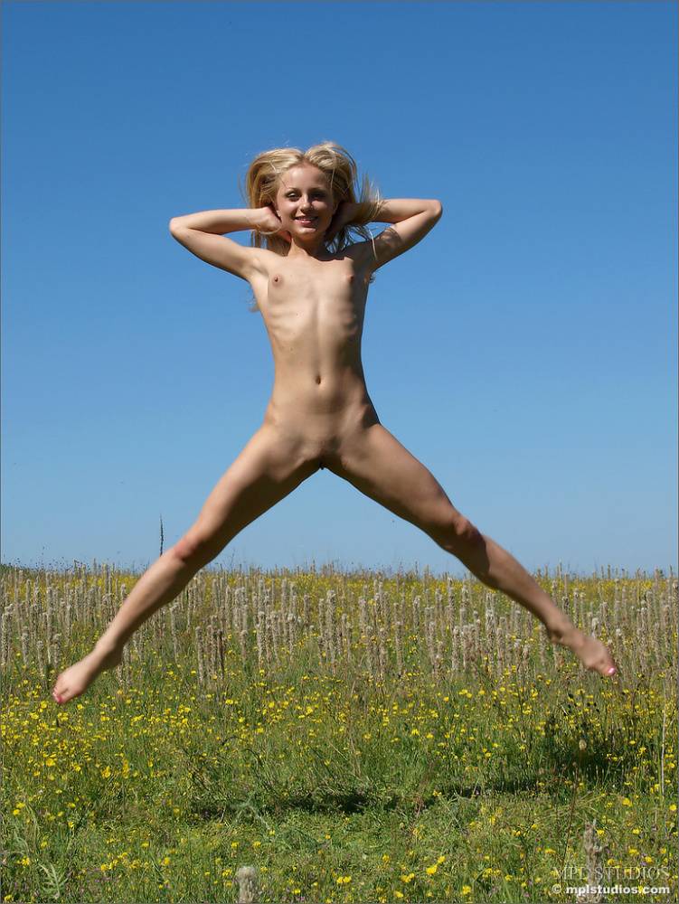 Skinny blonde girl romps around in a field of wild flowers and weeds - #10