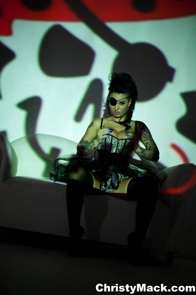 Solo girl Christy Mack wears an eye patch and lingerie while posing in shadows - #2