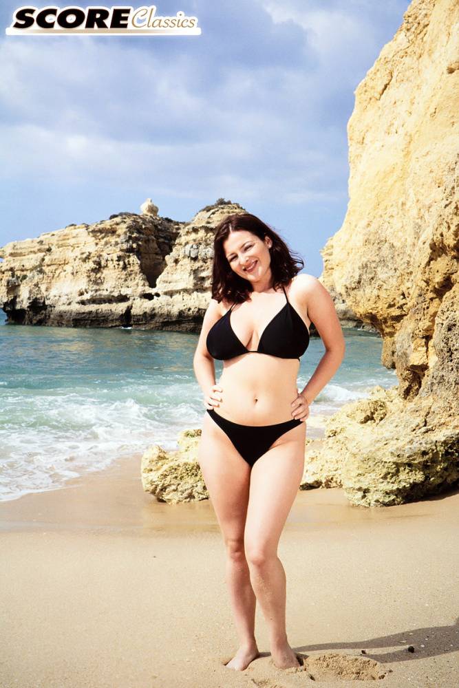 Brunette MILF Lorna Morgan releases her nice melons from bikini on a beach - #1