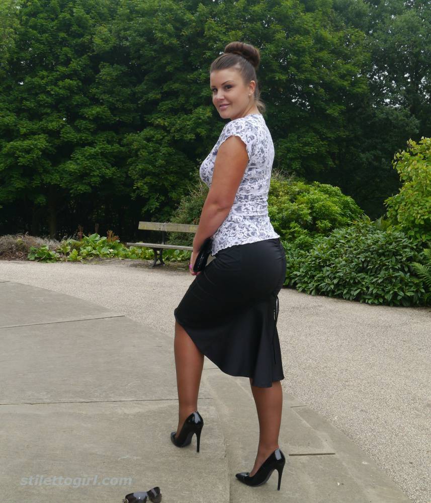 Clothed woman Karen displays her new stiletto heels at a park | Photo: 380672