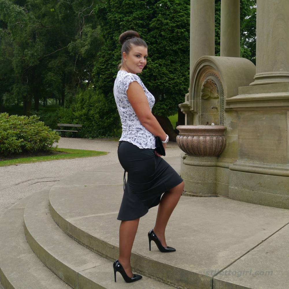 Clothed woman Karen displays her new stiletto heels at a park | Photo: 380637
