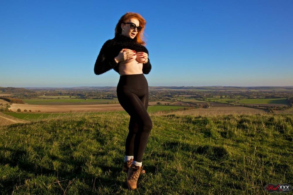 British woman with red hair uncovers her big boobs on a hill on a windy day - #10