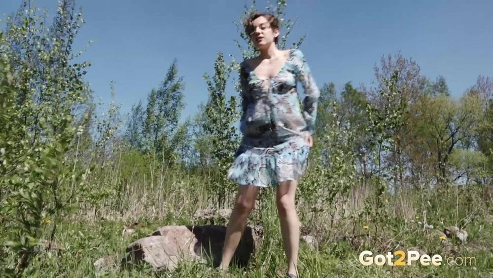Clothed woman Sasha S hitches up her dress to take a pee on a rock - #2