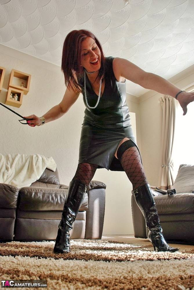 British redhead Juicey Janey hikes up a leather dress while wielding a flogger - #11