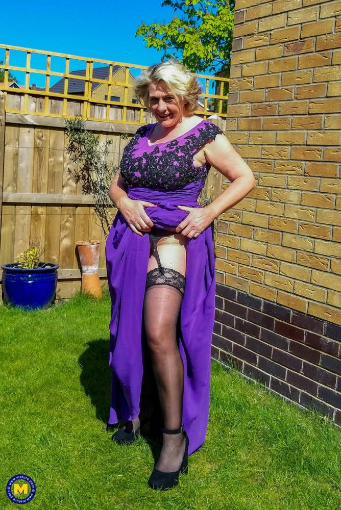 Old blonde woman flashes her garters in a yard before sex in the kitchen | Photo: 1015361