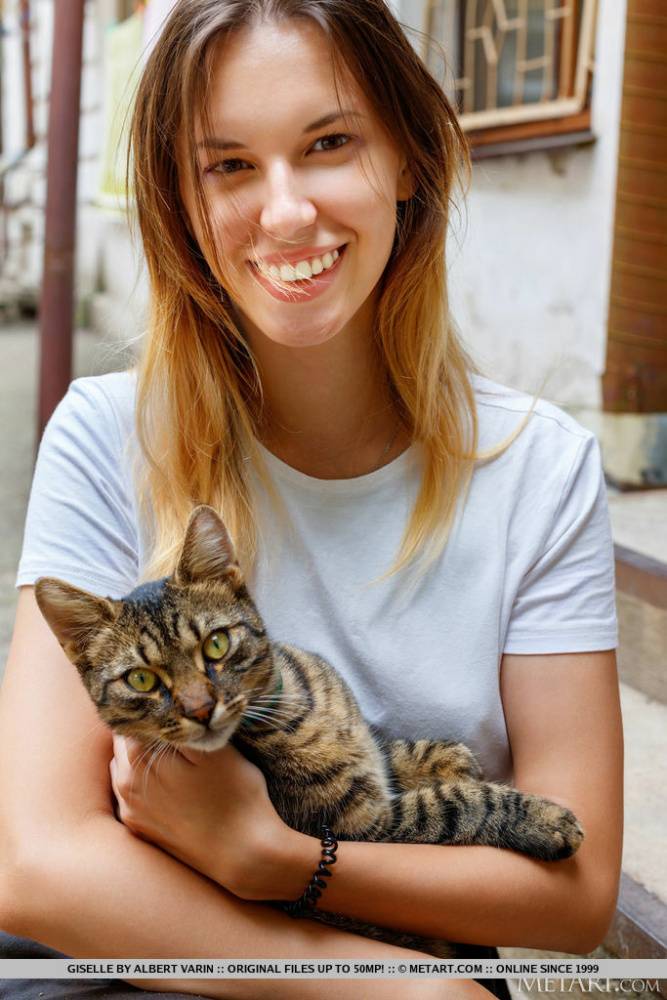 Teen solo girl Giselle holds a cat before getting totally naked - #1