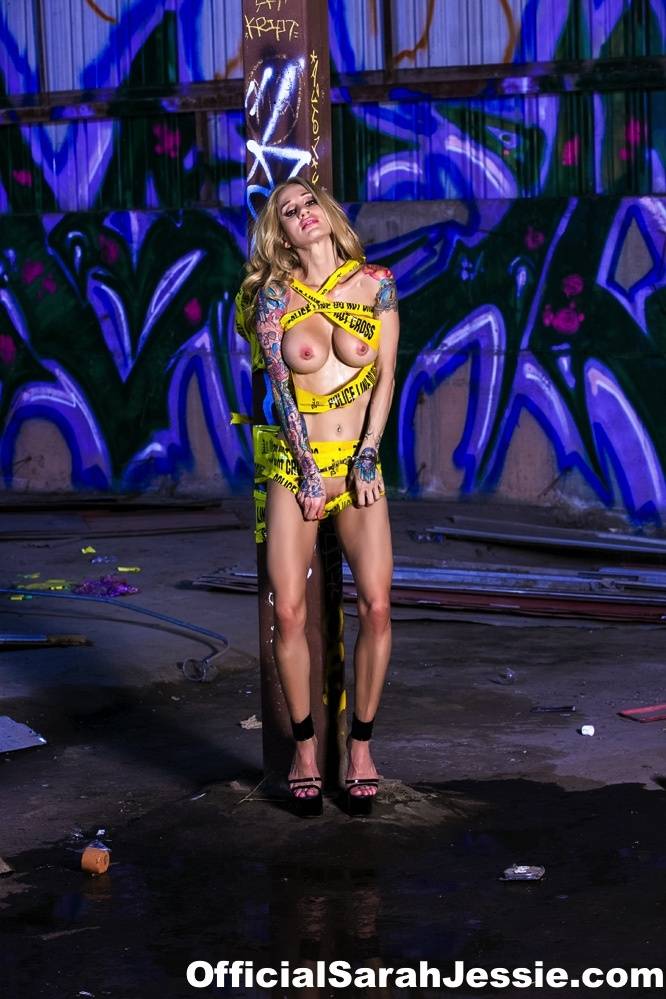 Inked blonde Sarah Jessie stands naked after getting clear of police line tape | Photo: 823052