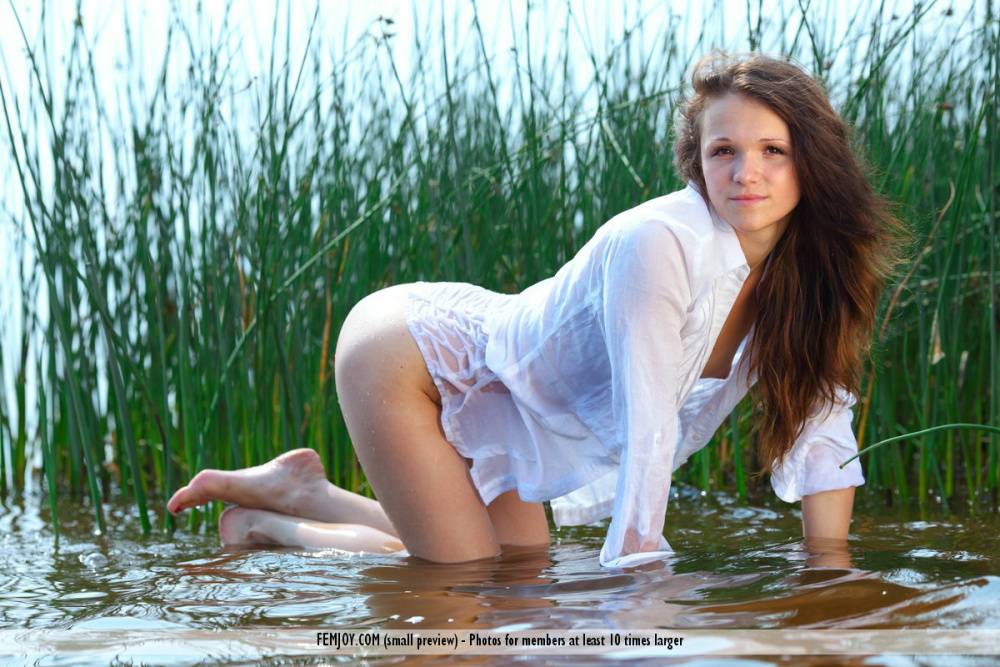 Solo girl Elvi T poses totally nude amid reeds in the water - #16