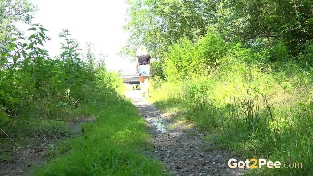European female Nikki Dream takes a piss while walking on a dirt path - #8