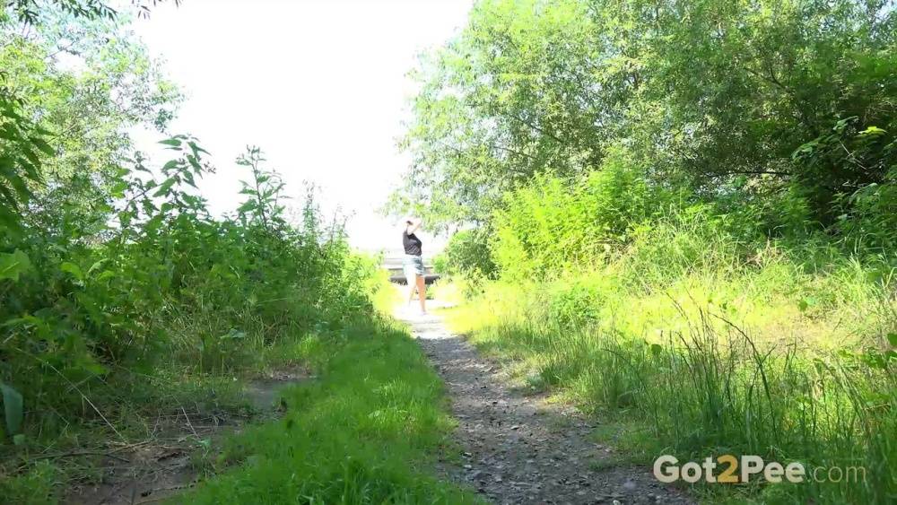 European female Nikki Dream takes a piss while walking on a dirt path - #11