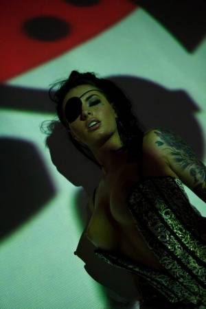 Solo girl Christy Mack wears an eye patch and lingerie while posing in shadows on realgirlsweb.com