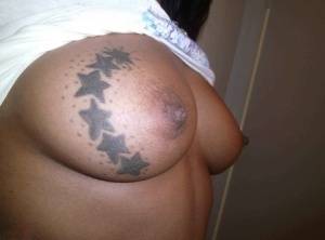 Ebony amateur takes self shots of her big tattooed boobs and bald vagina on realgirlsweb.com
