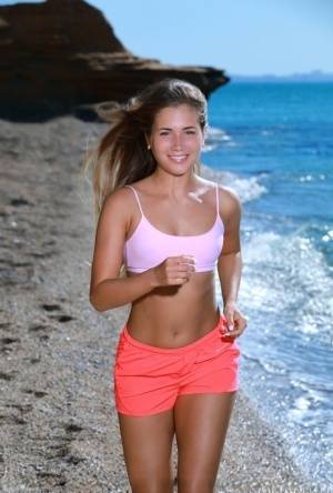 Fit young girl Mary Rock gets completely naked on a beach after exercising on realgirlsweb.com