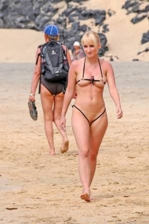 Hot blonde removes a skimpy bikini during a visit to a public beach on realgirlsweb.com