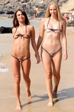 Best friends model revealing bikinis while wondering about a mud flat on realgirlsweb.com