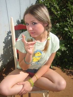 Cute teenage babe Shelby takes a smoke break and flashes us her perky tits on realgirlsweb.com