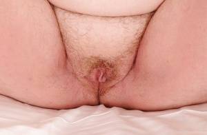 Mature plumper with huge saggy jugs and hairy cooter posing on the bed on realgirlsweb.com
