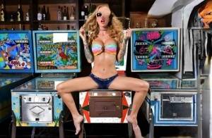 Inked chick Sarah Jessie toys her pussy atop a pinball machine while alone on realgirlsweb.com